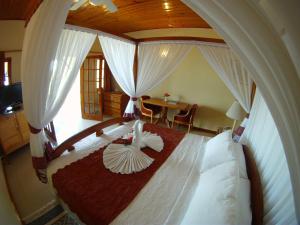 尼格瑞尔夏拉茵酒店的一间卧室配有一张带木制天篷的大床