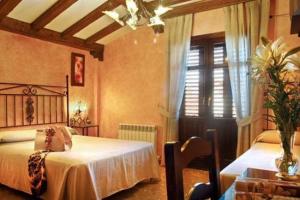阿尔法卡鲁塔日洛尔卡旅馆的一间卧室设有两张床、一张桌子和天花板
