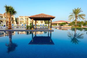 乌姆盖万Barracuda Resort的一个带凉亭和棕榈树的游泳池