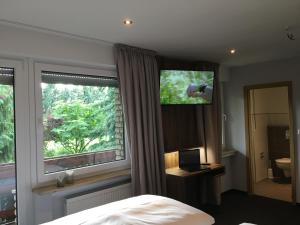 赫费尔霍夫Landhaus Hotel Göke的一间卧室设有一张床和一个带电视的窗户。