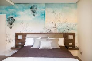 罗马罗姆旅馆的一间卧室配有一张带白色枕头的床和一幅画