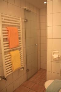 诺德奈Feriendomizil am Kurplatz的浴室提供橙色毛巾和淋浴。