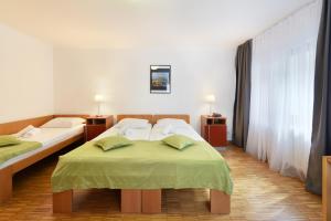 维也纳肯瑞托酒店的酒店客房,配有两张带绿床单的床