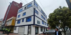 波哥大Hotel Blue Zafiro的一个人站在建筑物前面