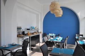 瓦尔拉普拉日Hôtel de la Mer的餐厅拥有蓝色的墙壁和桌椅