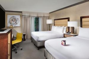阿什维尔阿什维尔皇冠假日度假酒店的酒店客房,设有两张床和一张黄色椅子