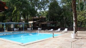 马卡帕瑟塔意科特酒店的一个带桌椅的游泳池以及一座房子