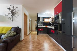 阿里纳加Las Salinas House的厨房配有黑红色橱柜和沙发