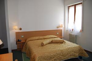 奥维多伊特鲁里亚酒店的一间卧室配有一张大床和木制床头板