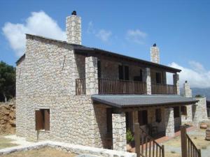 奥马洛斯撒马利亚乡村别墅的一座石头建筑,上面设有一个阳台