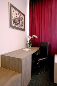 卢布尔雅那梅客斯可酒店的红色窗帘的房间的一张桌子