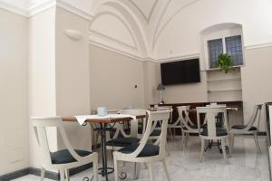 卡塔尼亚中央酒店的用餐室配有桌椅和平面电视。
