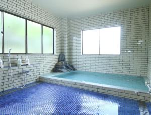 山中湖村苏梅索宾馆的一间带大浴缸及窗户的浴室