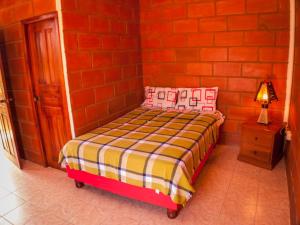普拉亚斯Sol de Playa的红砖墙房间里一张小床