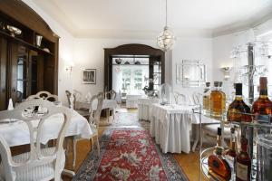 菲尔森Höhen Hotel Viersen的用餐室配有白色的桌子和白色的椅子