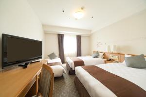 大阪大阪东急REI酒店的酒店客房设有两张床和一台平面电视。