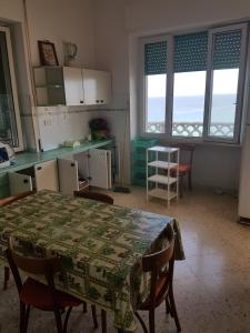 莫诺波利Villa Lilly的厨房配有桌子、椅子和桌子,部分设有窗户