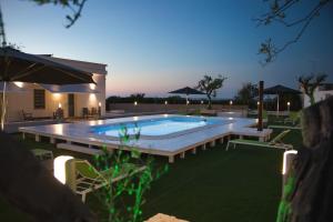 焦维纳佐Bed & Breakfast del Faro的夜间在院子里的游泳池