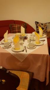 拉姆绍Haus Mühlgraben的一张白色的桌子,上面有黄色的帽子和盘子