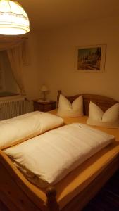 拉姆绍Haus Mühlgraben的一间卧室配有两张带白色床单和灯的床