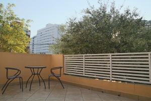 圣保罗Villa Hostel SP - Próximo ao Allianz Parque的庭院设有两把椅子和一张桌子,