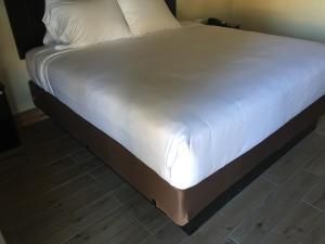 科尔顿科尔顿酒店的铺有木地板的白色床单床