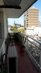 萨尔托Los Naranjeles Centro Flat的大楼内的阳台配有两把椅子和长凳