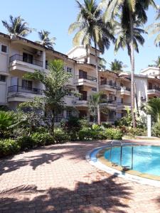 卡兰古特Mariano Gracinda resort的一个带游泳池和棕榈树的度假村