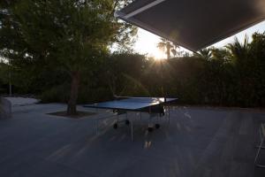 焦维纳佐Bed & Breakfast del Faro的一张乒乓球桌,背面是太阳