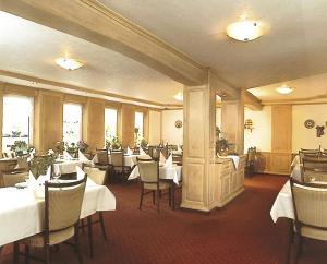 伦讷施塔特格斯特雷希旅馆的餐厅配有桌椅和白色桌布
