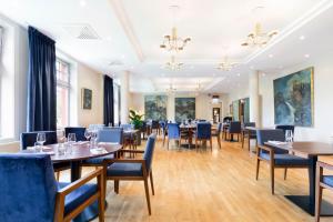 蒂瑟达尔蒂瑟达尔酒店的一间配备有桌子和蓝色椅子的用餐室