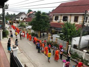 琅勃拉邦琅勃拉邦茉莉花酒店的一群穿着橙色长袍的人在街上走