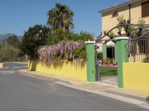 吉拉索莱Villa Hermosa的街道边的黄色和绿色围栏