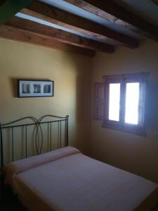 Cervera de Buitrago厄埃易高酒店的一间卧室设有一张床和两个窗户。