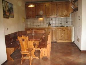 塞斯托拉Residence Fontanelle的厨房配有木桌和木橱柜。