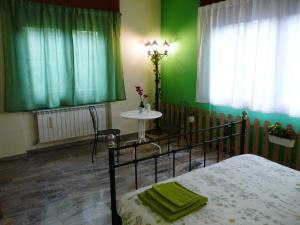 卡西纳佩齐花园住宿加早餐旅馆的一间卧室设有绿色的墙壁、一张床和一张桌子