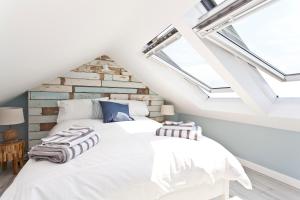 伯恩茅斯Coastguard Cottage的配有天窗的客房内的一张白色床