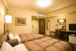 大仙市大曲站前路线酒店的酒店客房设有四张床和电视。