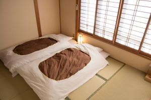 本宫J-豪普尔斯库玛诺玉诺米内旅馆的小房间,配有一张带毯子的床