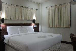 邦劳地平线海滩潜水度假酒店的卧室配有一张白色大床和两条毛巾