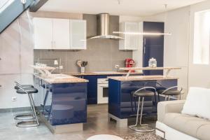 斯特拉斯堡LE LOFT 67的厨房配有蓝色橱柜和酒吧凳子
