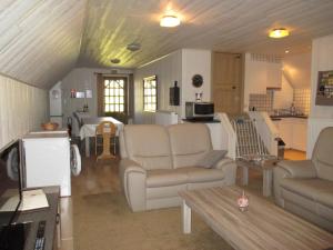里提Vakantieverblijf-Beestenboel的一间带两张沙发的客厅和一间厨房
