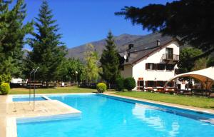 埃斯特里-德阿内乌艾格斯托假日公园的一座大蓝色游泳池,位于房子前