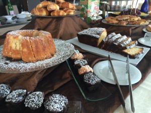 普尔萨诺伊尔格里洛酒店的一张桌子,上面放有不同种类的蛋糕和糕点
