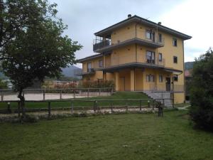 PreturoIl Boscaiolo Affittacamere的一座黄色的大房子,前面有栅栏