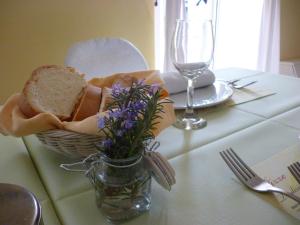 Monte Grimano TermeHotel "La Salute"的一张桌子,上面放着一篮面包和一瓶鲜花