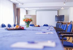 柏林柏林多米希尔金色郁金香酒店的一间会议室,里面设有一张长桌和花瓶