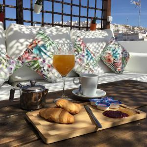 阿尔科斯-德拉弗龙特拉Hotel Posada de las Cuevas的一张桌子,上面放着一杯橙汁和一盘面包