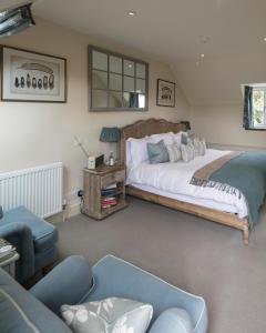 金汉姆The Kingham Plough的一间卧室配有一张大床和一张沙发