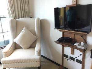 乔木提恩海滩Venetian Signature PoolAccess Resort Jomtian Pattaya的客厅配有白色椅子和平面电视